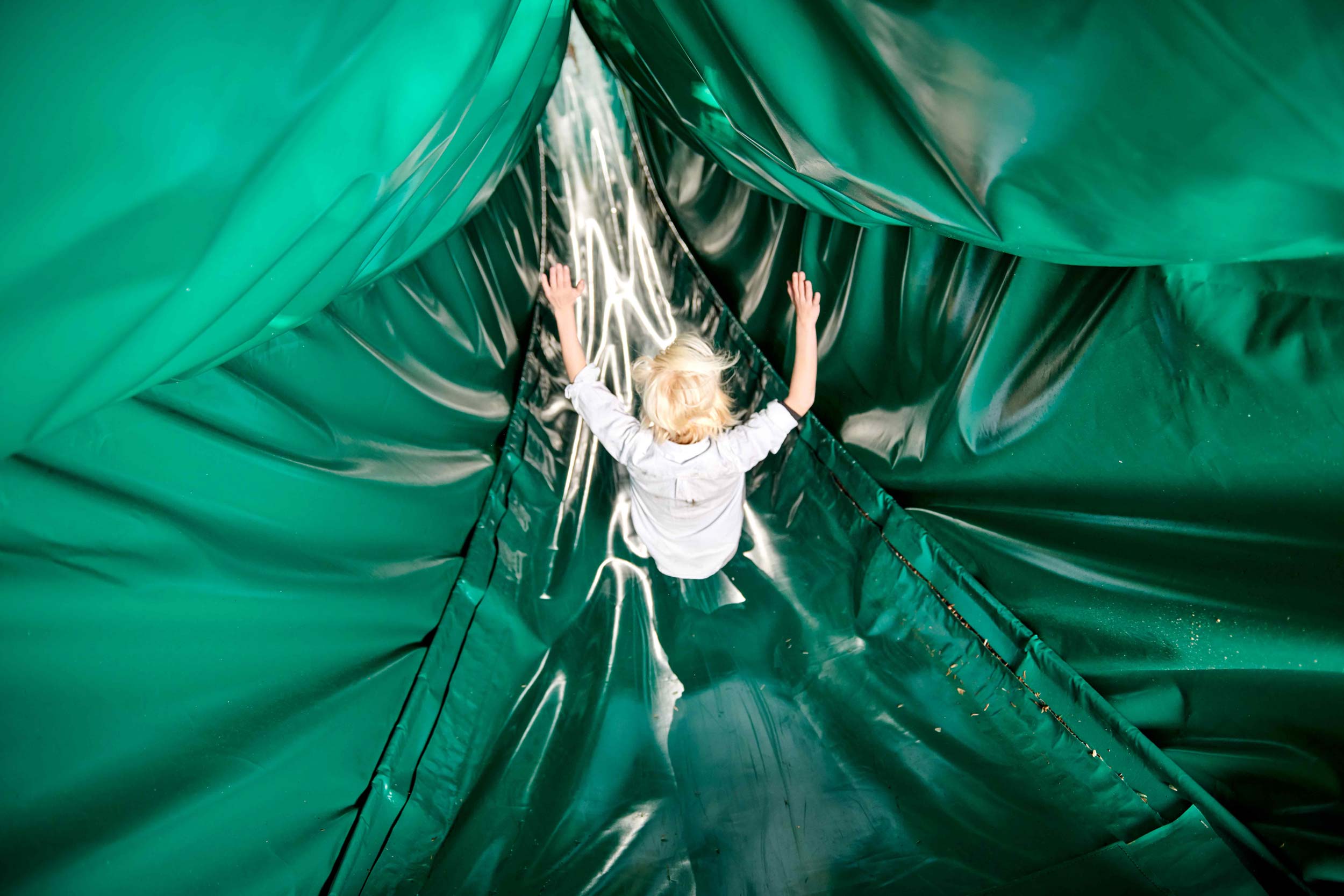 A boy is on his way down a slide.