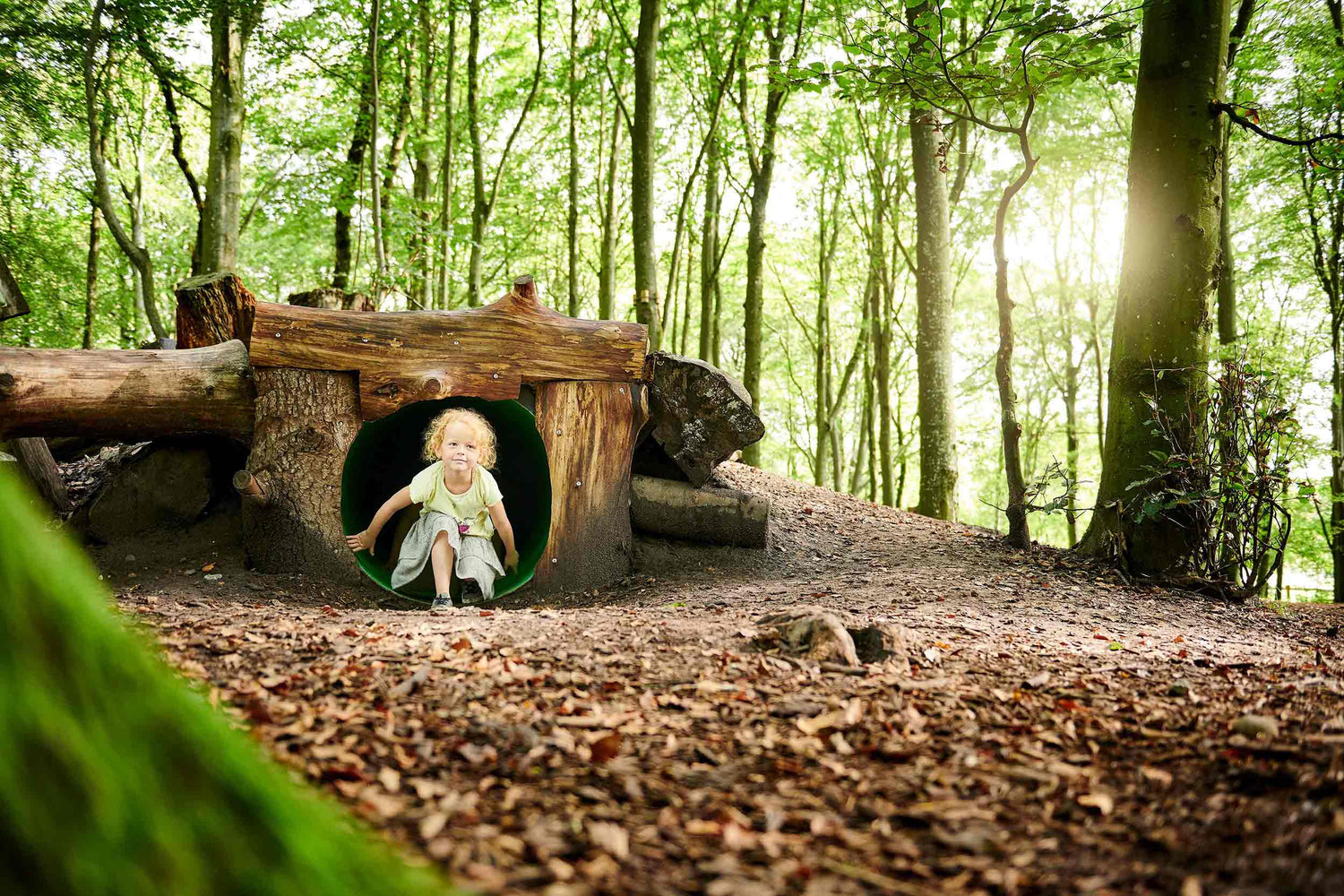 Ein kleines Mädchen sitzt am Ende einer Höhle im WOW PARK Skjern.