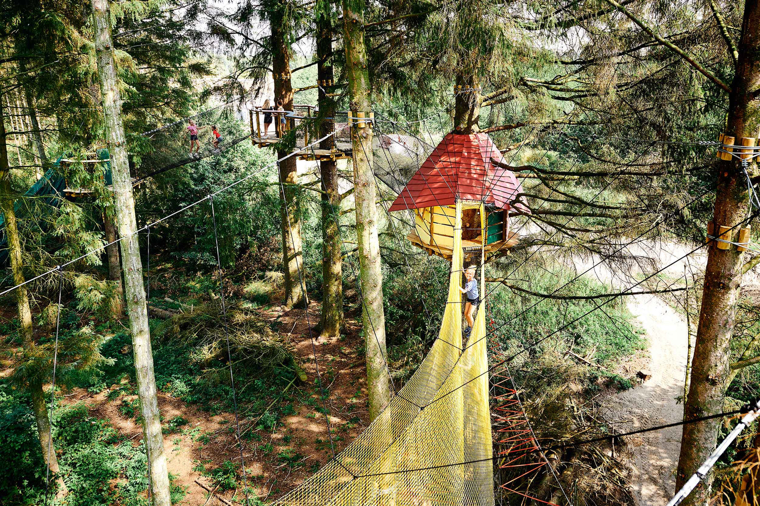 A girl is walking high up in a net.