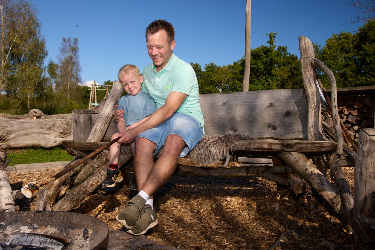 A father and son making s’mores by a bonfire at WOW PARK.