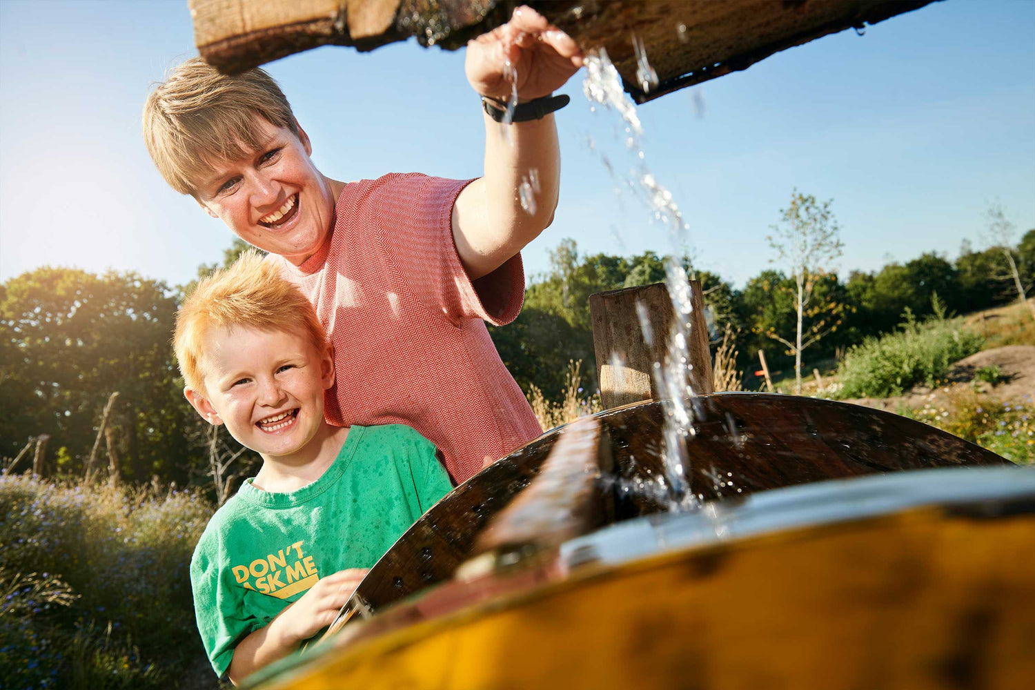 A boy and his mother are playing with water at WOW PARK Billund.