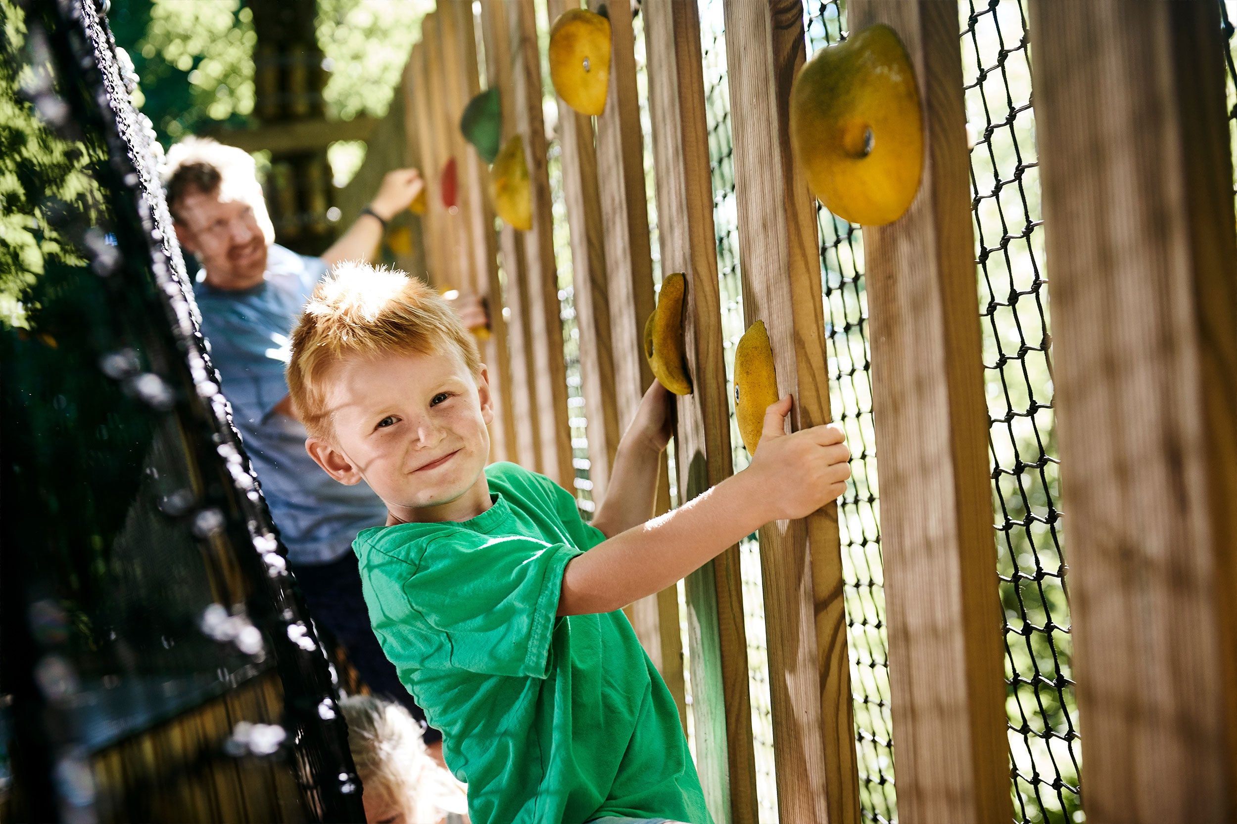 Ein Vater und sein Sohn haben Spaß und gehen über eine Netzhängebrücke im WOW PARK.