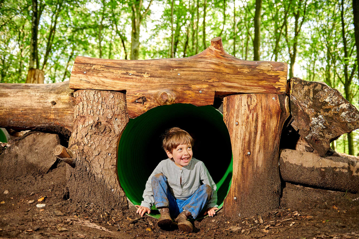 Kleiner Junge schaut aus einer unterirdischen Höhle im WOW PARK.