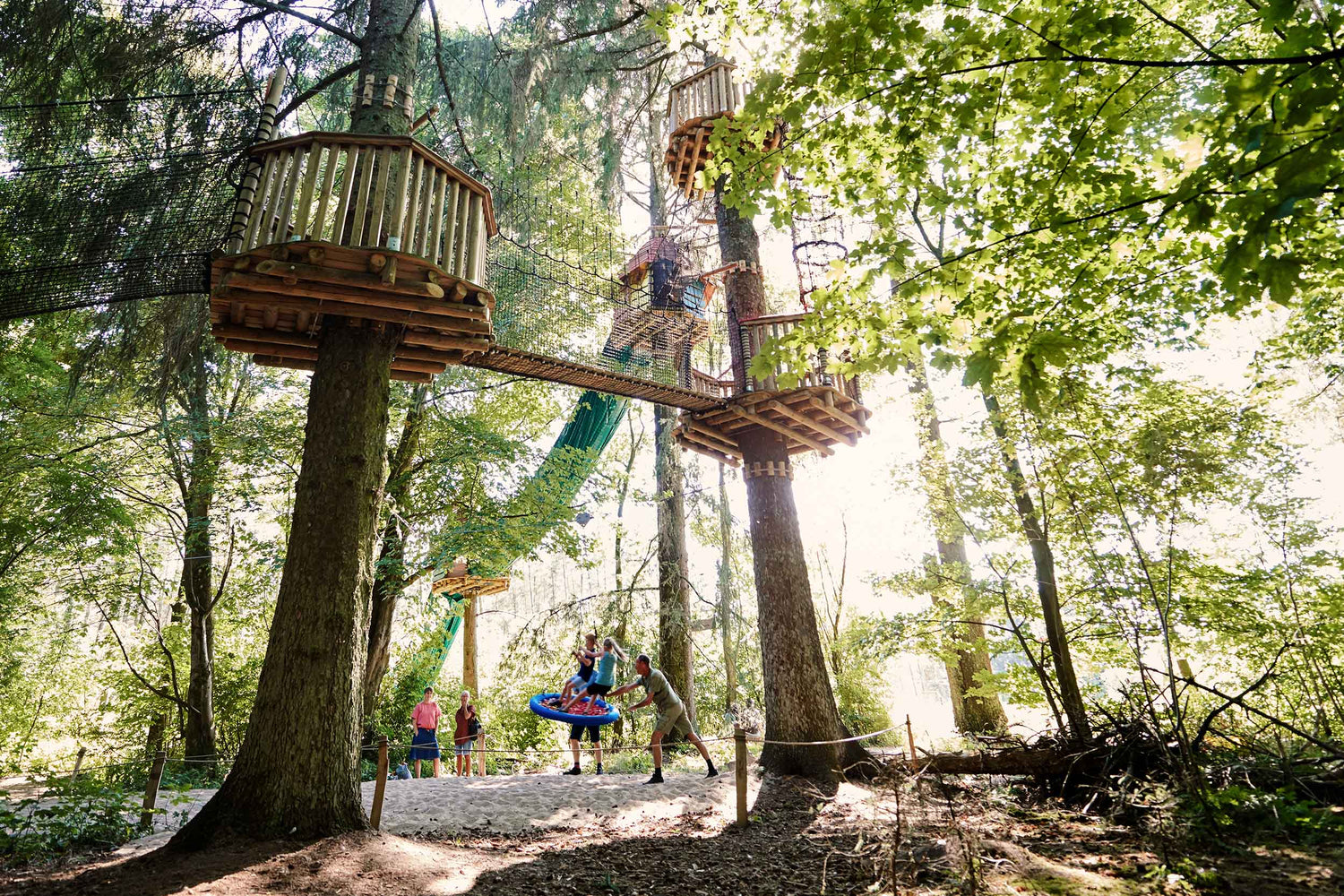 Bäume mit Baumhäusern, Netzbrücken und Seilrutschen im WOW PARK Billund.