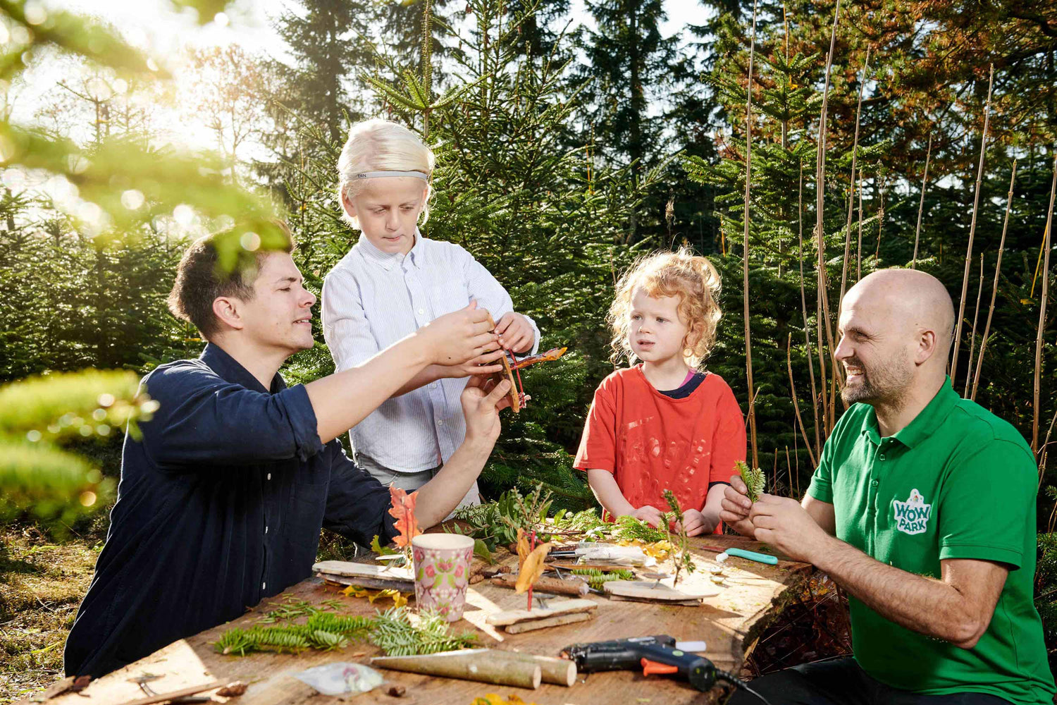 Børn og voksne hygger sig ved bord udendørs i WOW PARK Billund