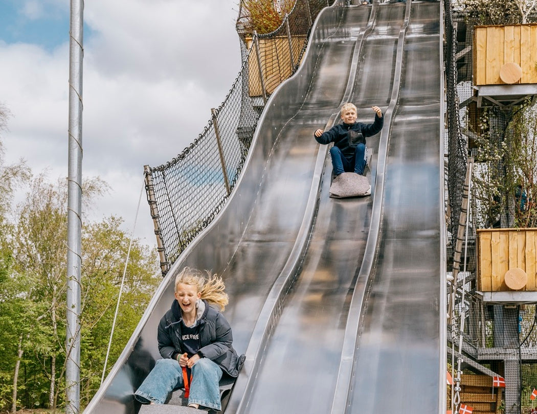 To børn på vej ned ad Skovraceren i WOW PARK Billund.
