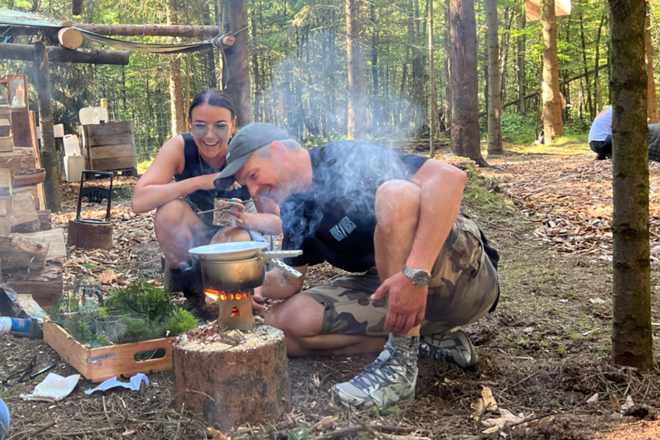 Two people cooking in the forest at a team event in WOW PARK.