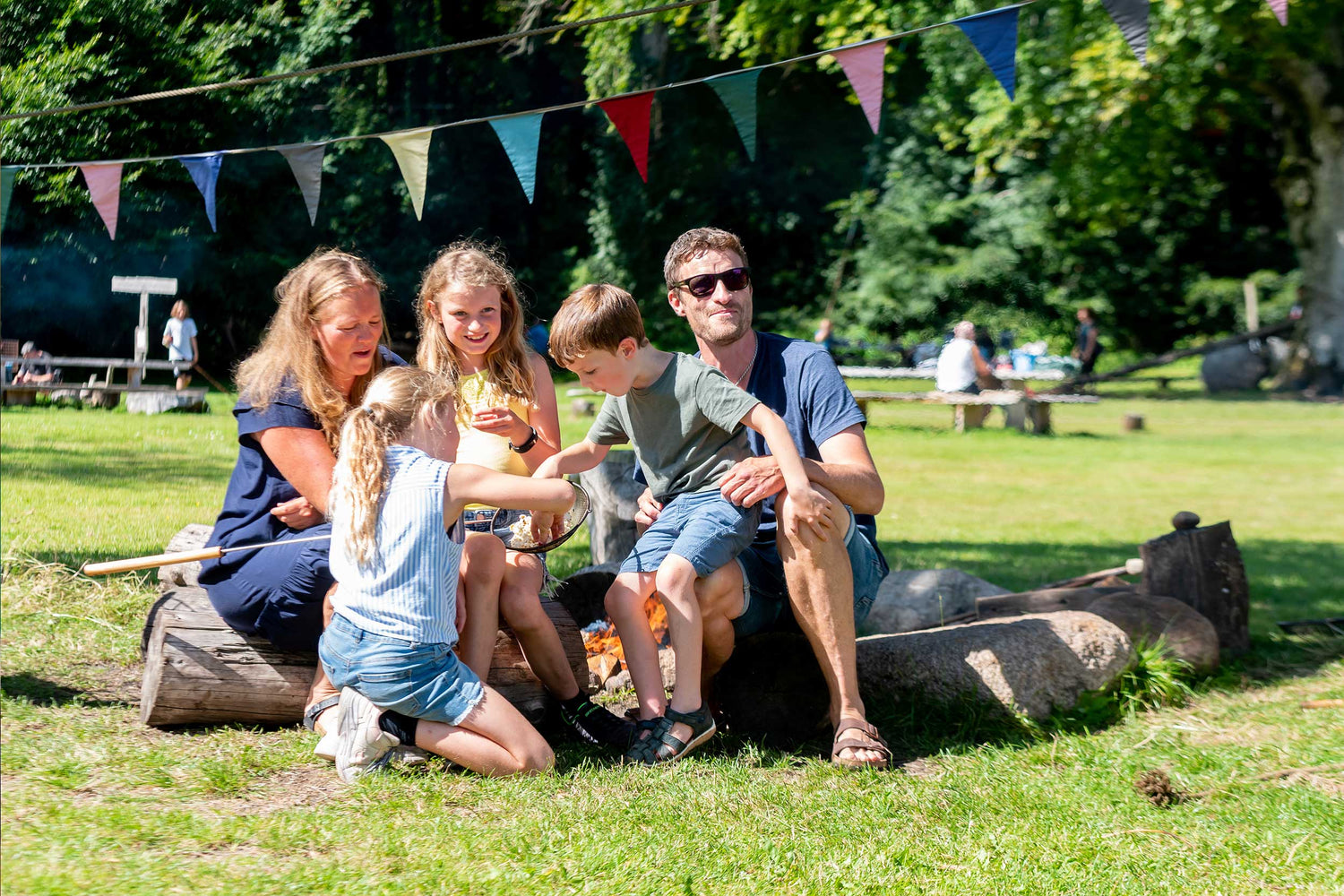 En familie sidder og hygger sig i parken i WOW PARK Skjern