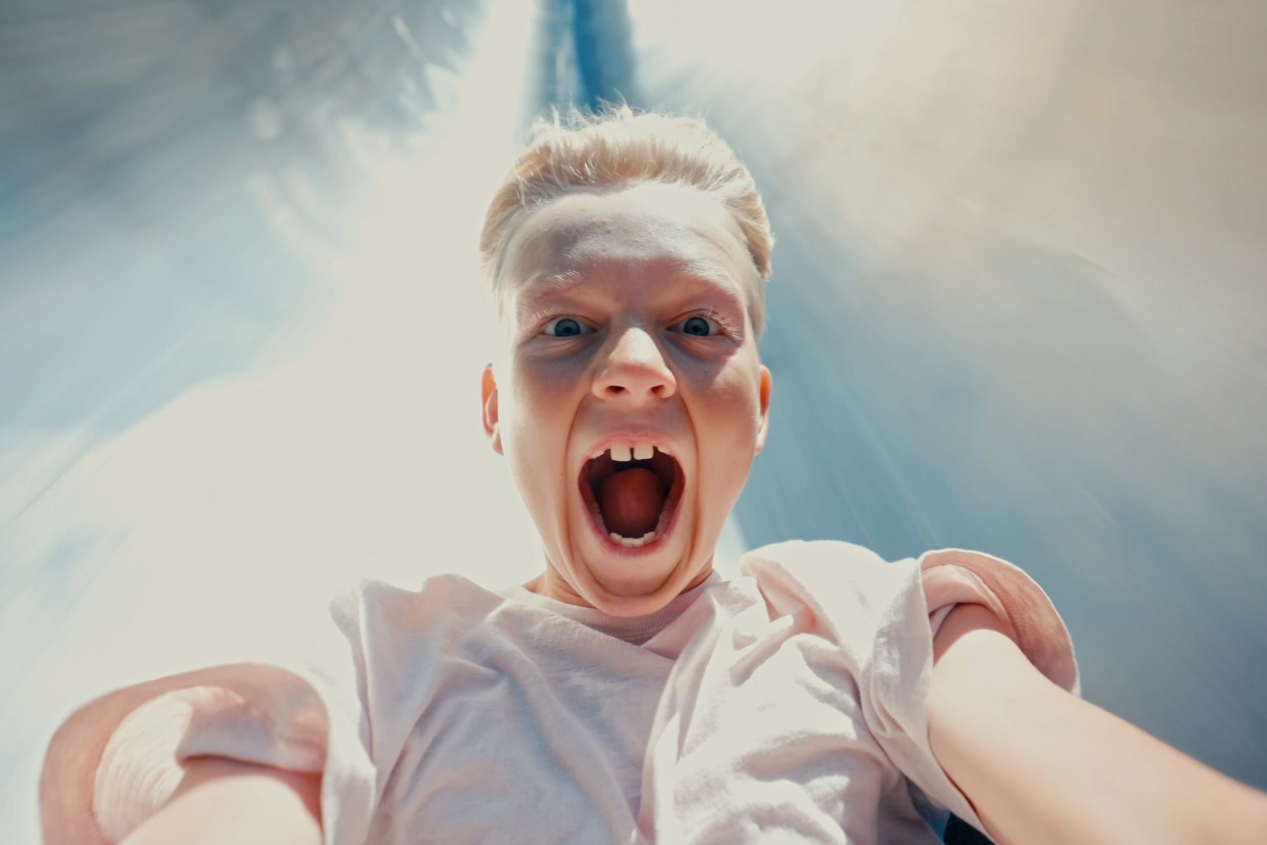 A boy looks quite startled on his way down the LIGHTNING at the GIANT in WOW PARK Billund.