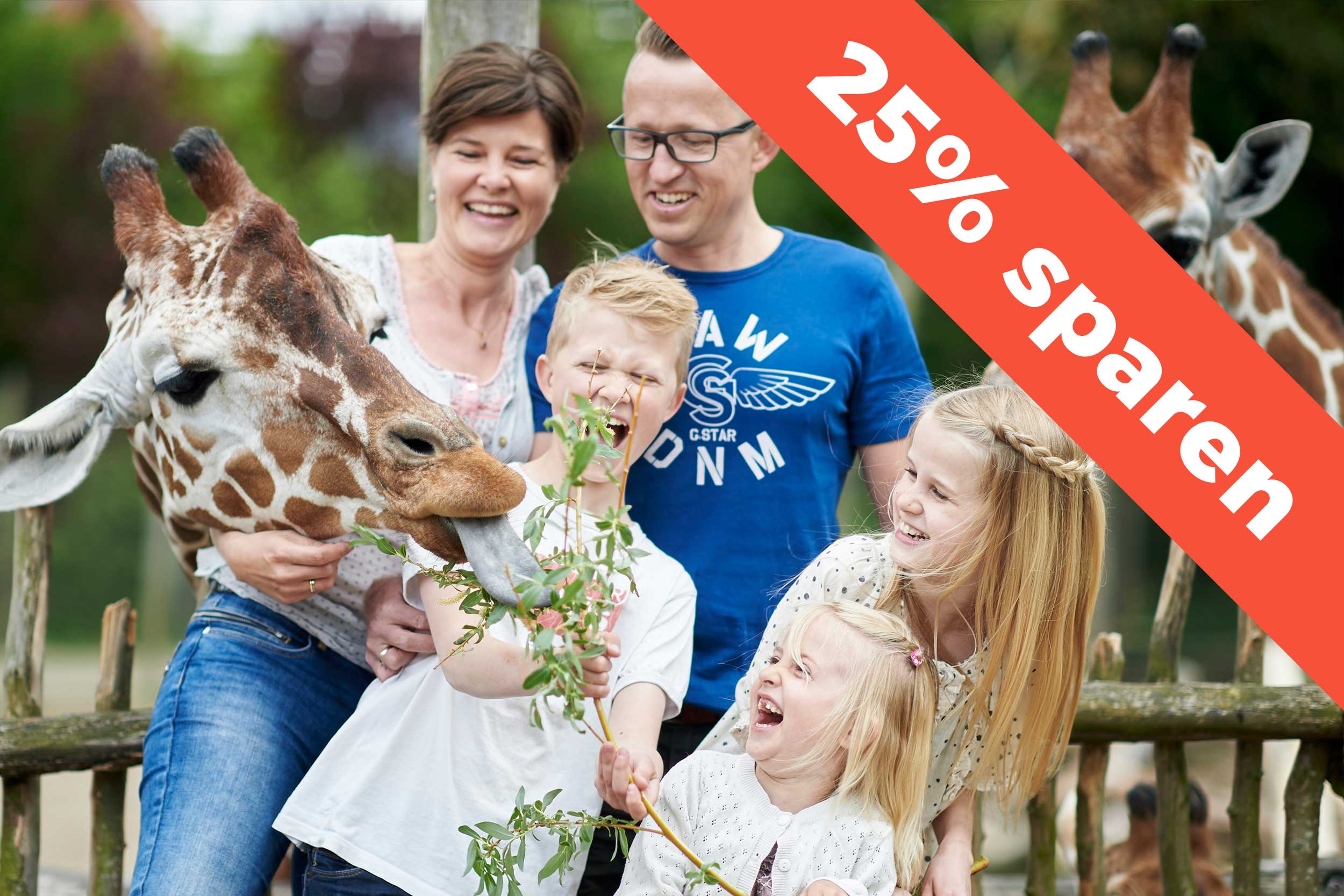 Eine glückliche Familie, die bei einer Giraffe im Odense Zoo steht.